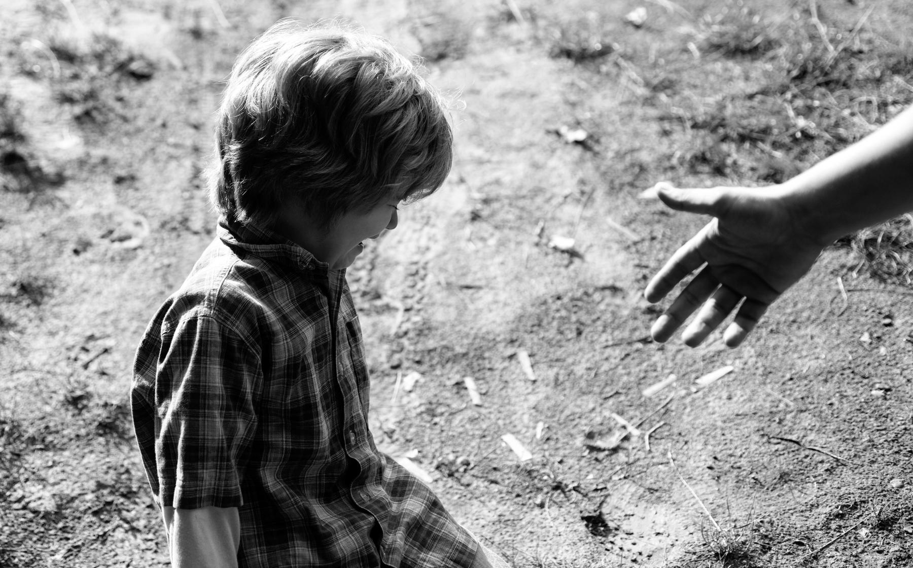 An adult hand reaching out to a crying child