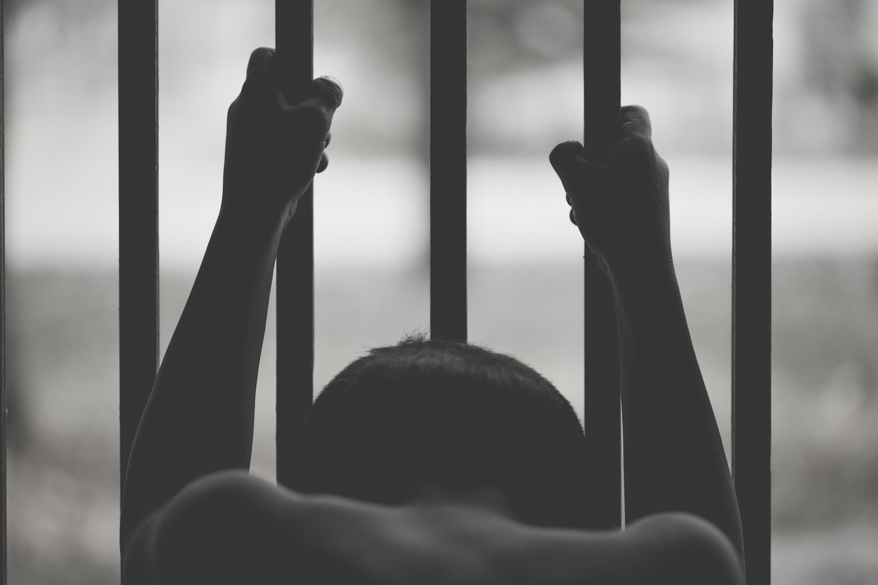 A child holding the bars of a window